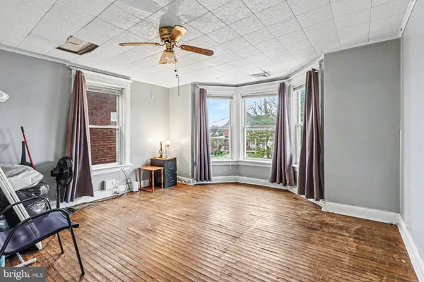 a view of a livingroom with a chandelier fan and wooden floor