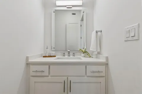 a bathroom with a sink vanity and a mirror