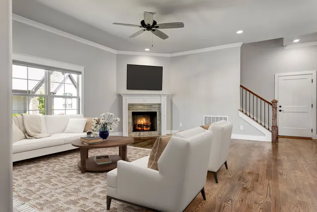 a living room with furniture a fireplace and a flat screen tv