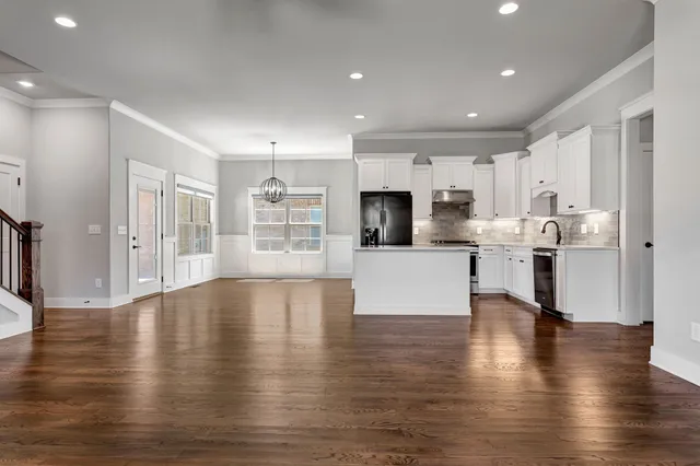 a view of kitchen with microwave stove refrigerator and cabinets