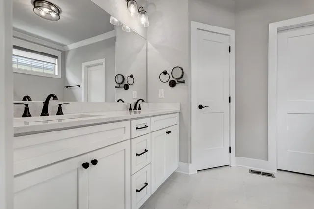 a bathroom with a double vanity sink a mirror and shower