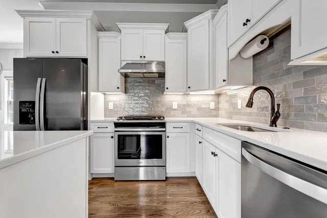 a kitchen with stainless steel appliances kitchen island a sink stove and refrigerator