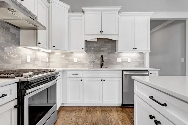 a kitchen with granite countertop white cabinets and white stove