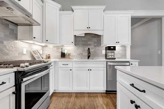a kitchen with cabinets appliances and wooden floor