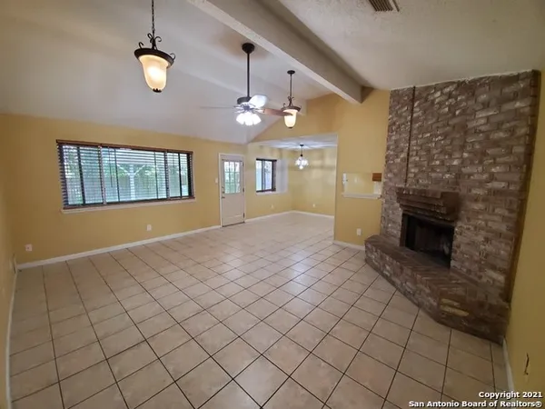 an empty room with windows and fireplace