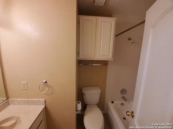 a bathroom with a granite countertop toilet and a sink