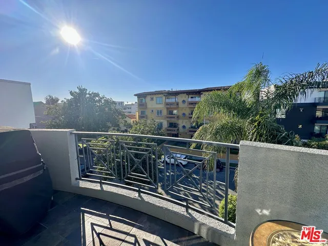 a view of a balcony with chairs and wooden fence