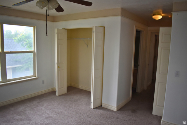 3327 East Windhover Road Eagle Mountain, UT 84005 - Photo 14 of 38 Carpeted bedroom featuring a ceiling fan with light fixture, large window, and bi-fold closet doors with wire shelving