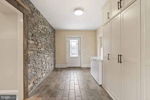 an empty room with wooden floor a fireplace a ceiling fan and wooden floor