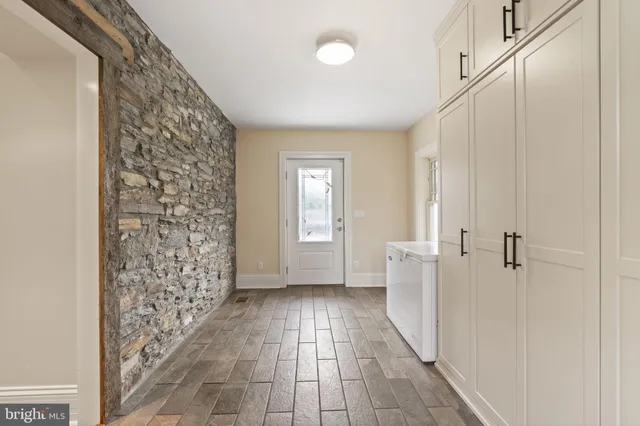 an empty room with wooden floor a fireplace a ceiling fan and wooden floor