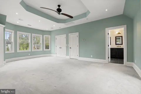 an aerial view of a house with swimming pool and large trees