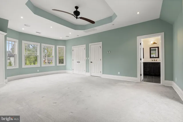 an aerial view of a house with swimming pool and large trees