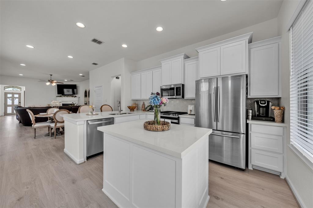 228 Palo Duro Bend Rhome, TX 76078 - Photo 8 of 35 a kitchen with white cabinets and stainless steel appliances
