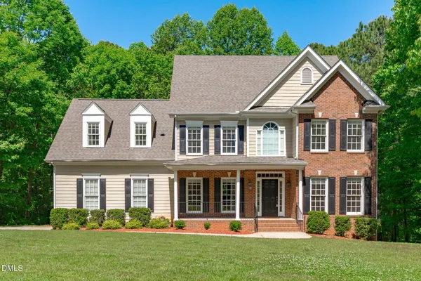 front view of a brick house with a yard