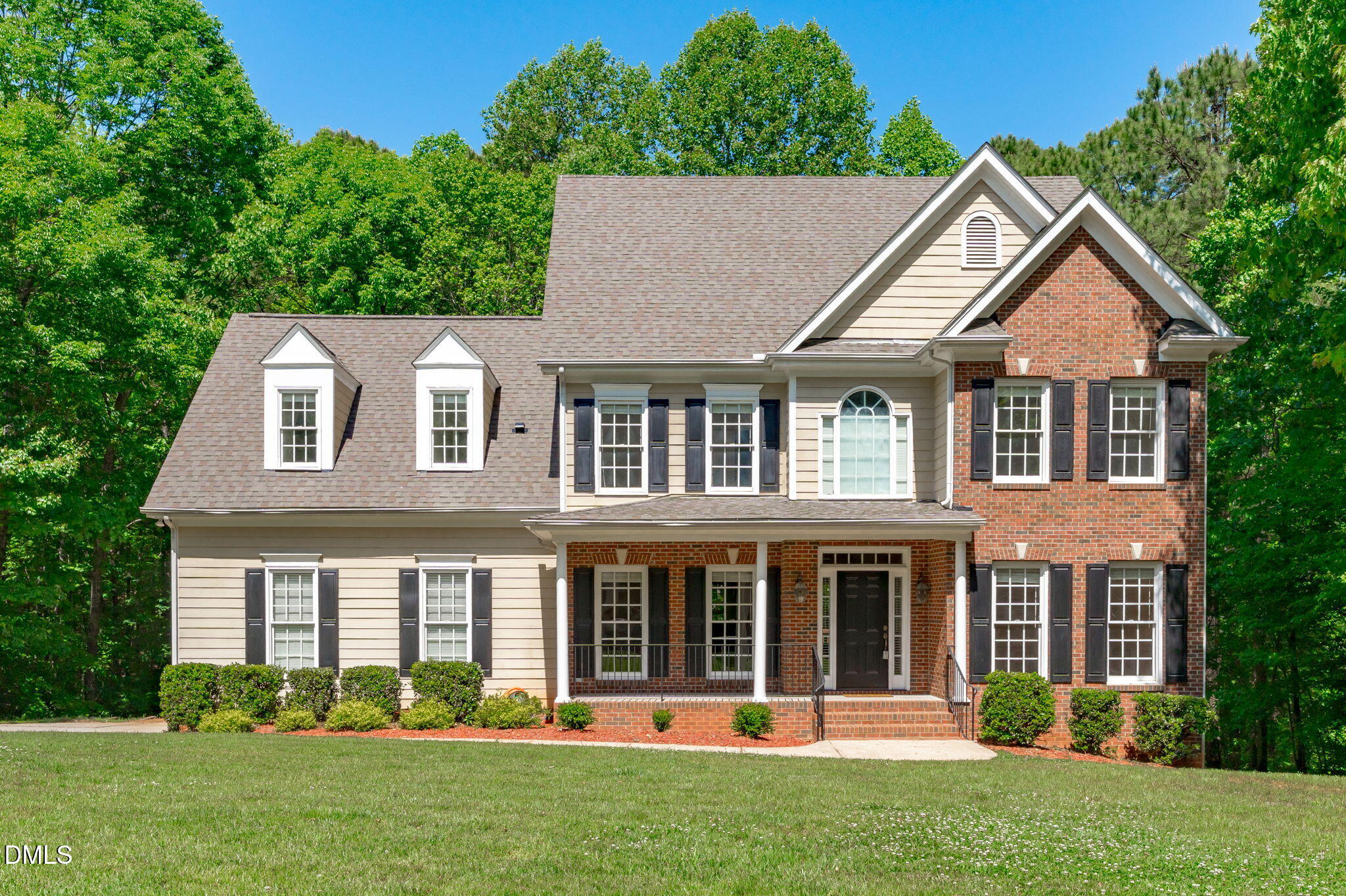 front view of a brick house with a yard