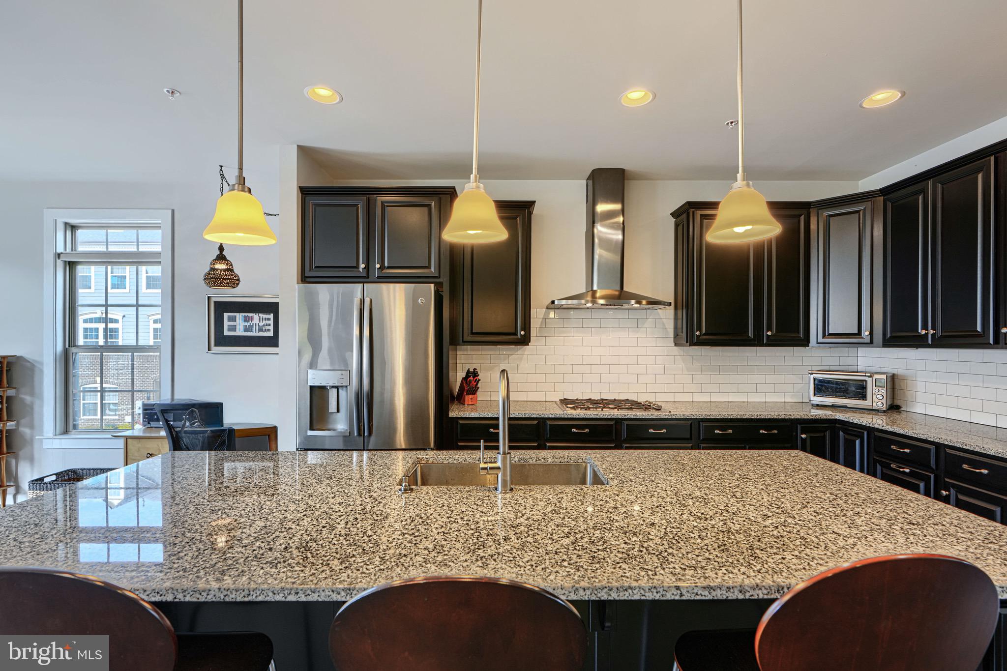 30 Wedge Way, Unit 12 Baltimore, MD 21208 - Photo 12 of 42 a kitchen with kitchen island granite countertop a sink and a refrigerator