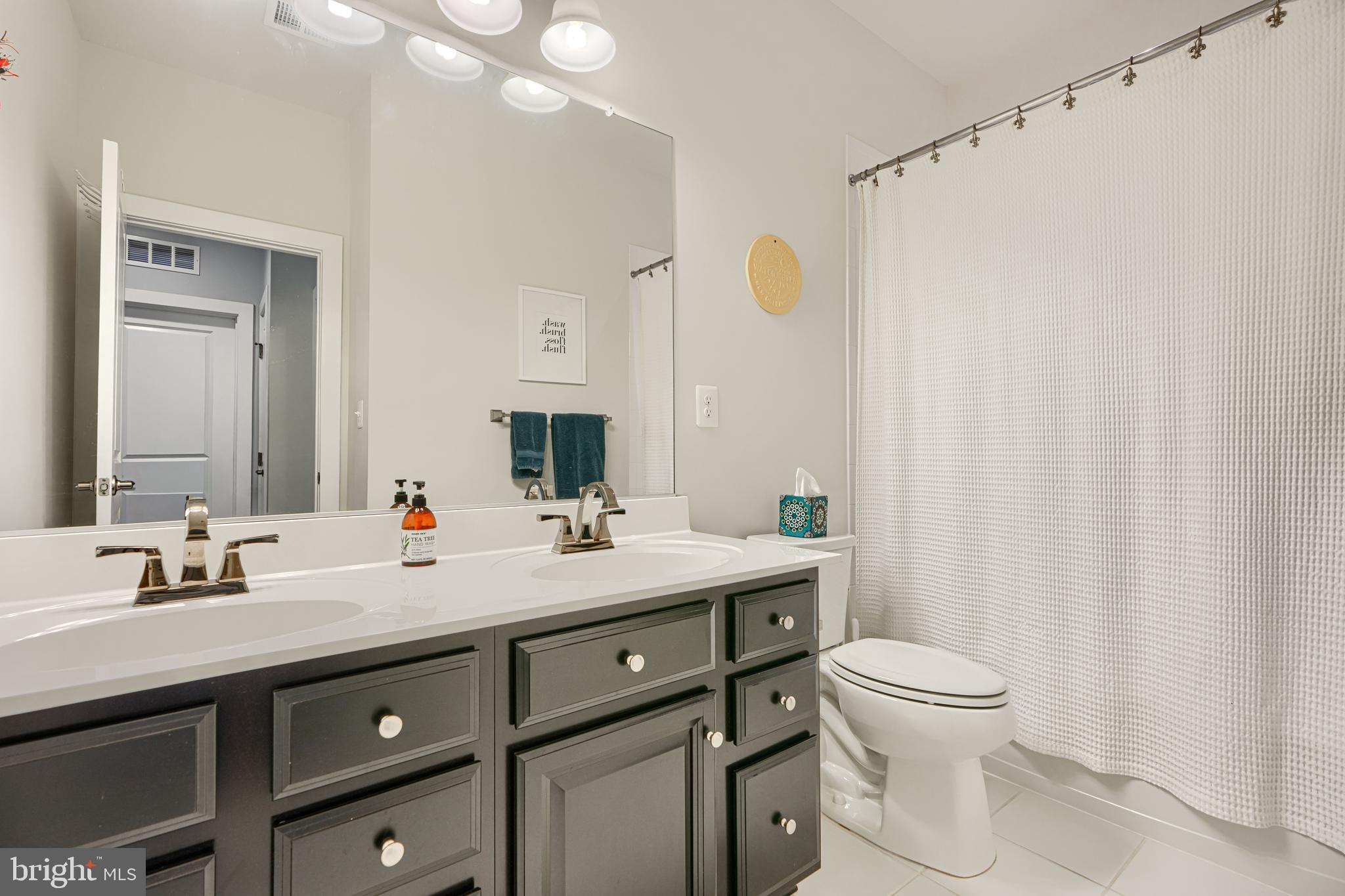 30 Wedge Way, Unit 12 Baltimore, MD 21208 - Photo 36 of 42 a bathroom with a toilet sink and mirror
