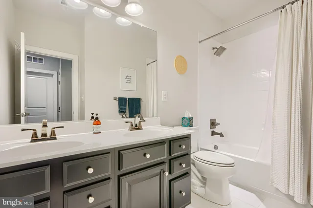 a bathroom with a double vanity sink toilet and shower