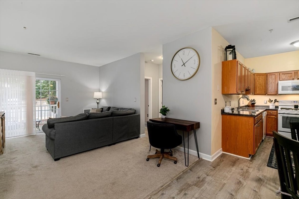 23 Hampshire Road, Unit 108 Methuen, MA 01844 - Photo 4 of 39 a living room with furniture a rug and a clock