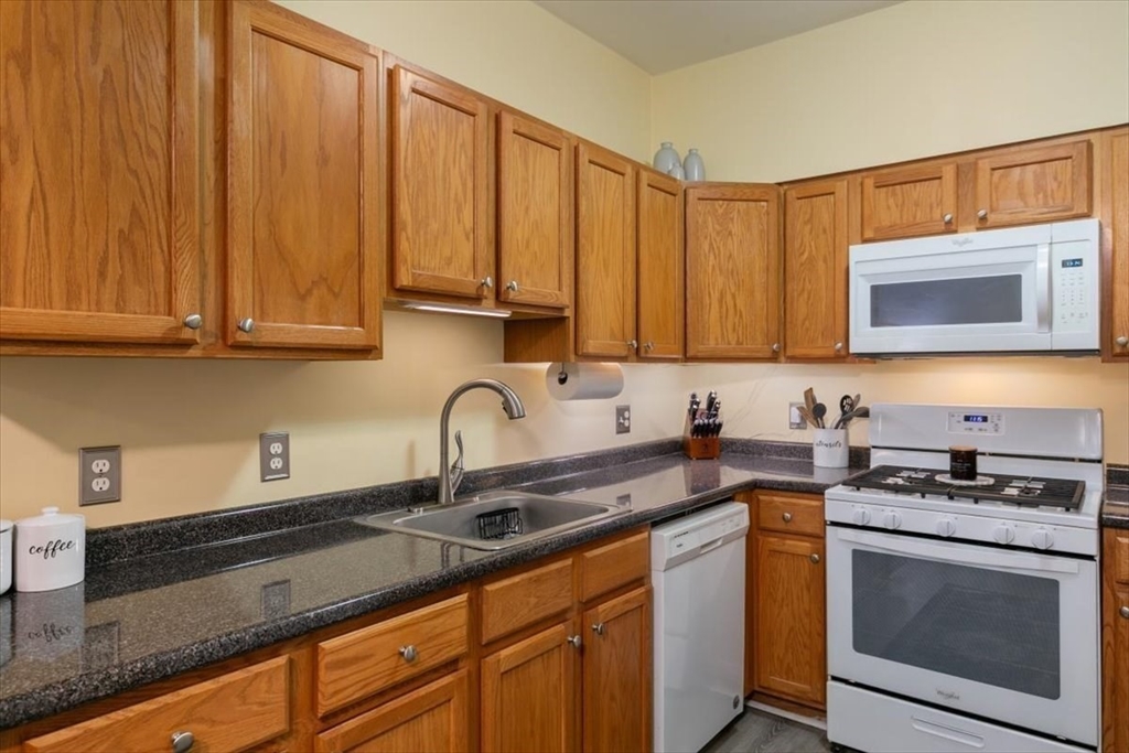 23 Hampshire Road, Unit 108 Methuen, MA 01844 - Photo 5 of 39 a kitchen with stainless steel appliances granite countertop a sink stove and microwave