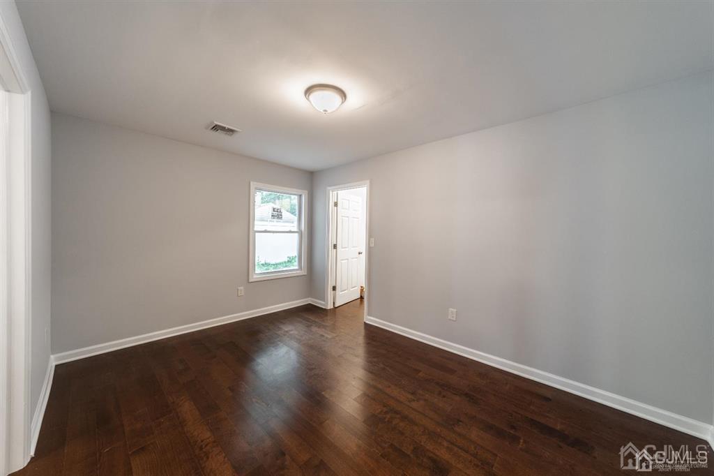 107 Winthrop Road Edison, NJ 08817 - Photo 16 of 38 a view of an empty room with wooden floor and a window