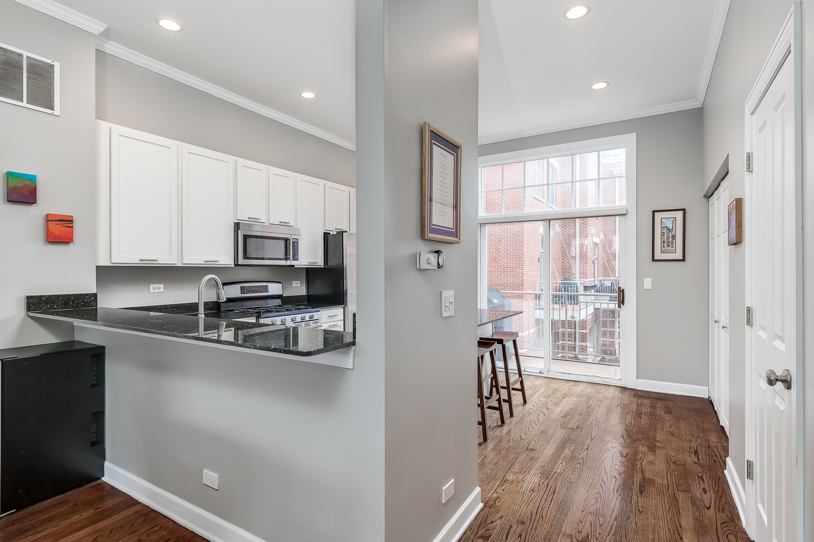 847 North May Street Chicago, IL 60642 - Photo 13 of 32 a kitchen with stainless steel appliances granite countertop a refrigerator a stove top oven a sink dishwasher and white cabinets with wooden floor