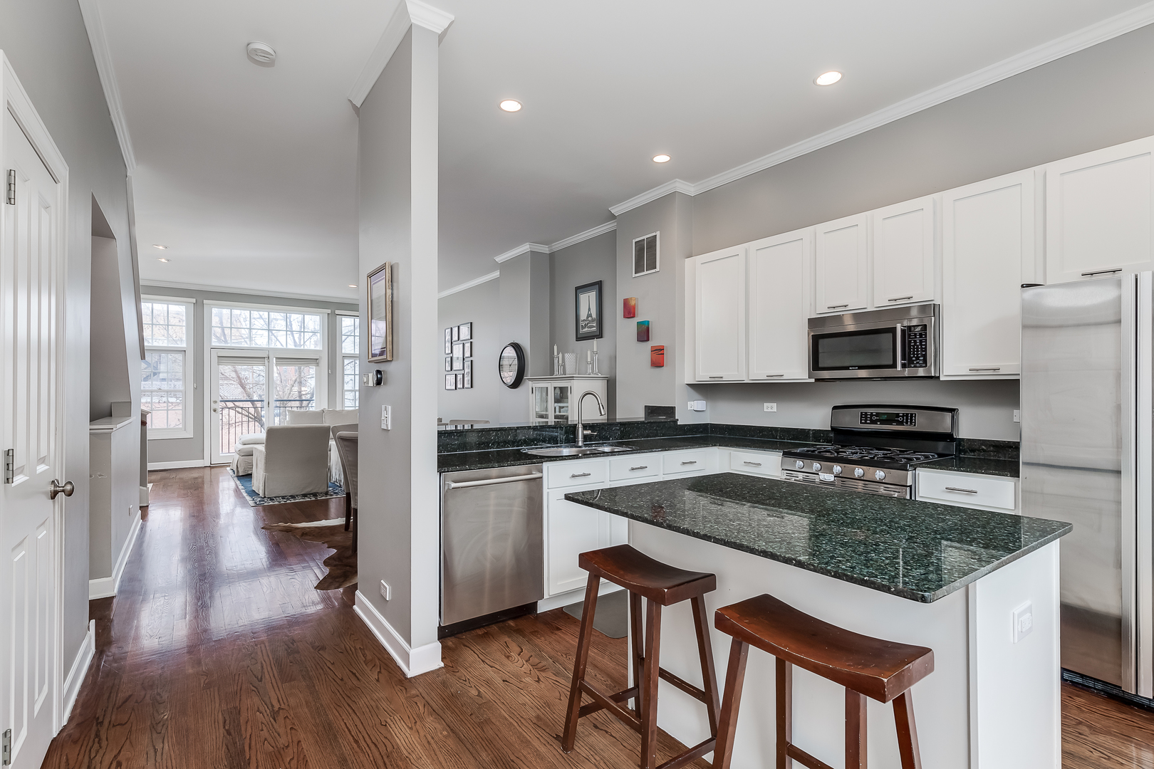 847 North May Street Chicago, IL 60642 - Photo 16 of 32 a kitchen with a center island wooden floor and stainless steel appliances