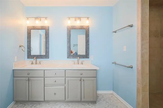 a bathroom with a double vanity sink and mirror