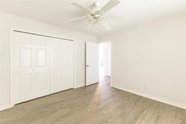 an empty room with a windows and fan