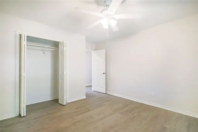an empty room with a ceiling fan and a window