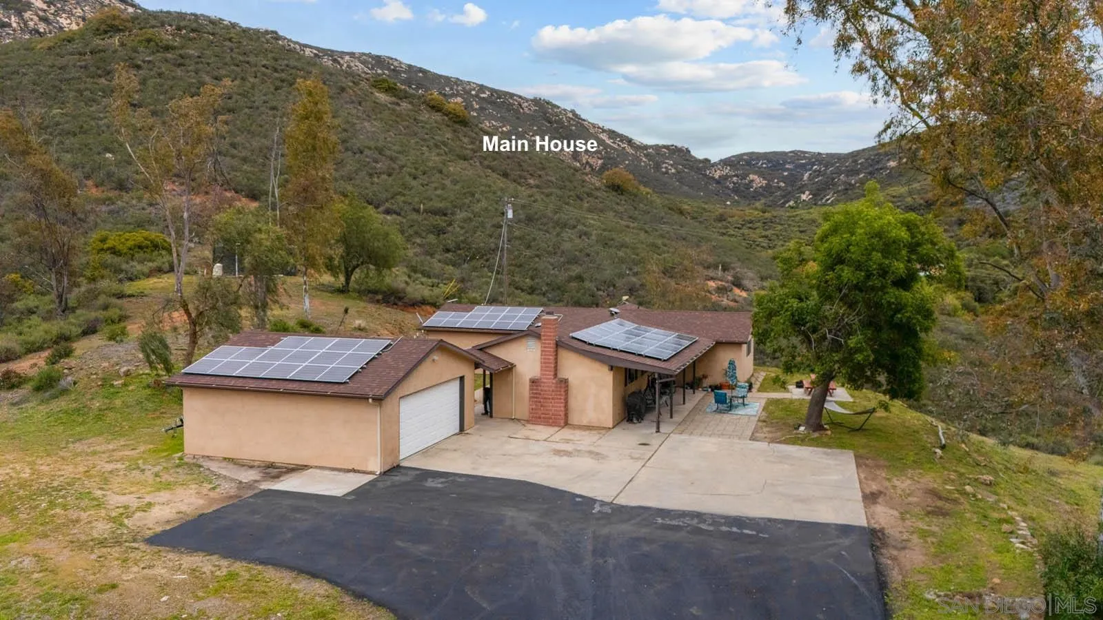 a view of a house with a yard and sitting area