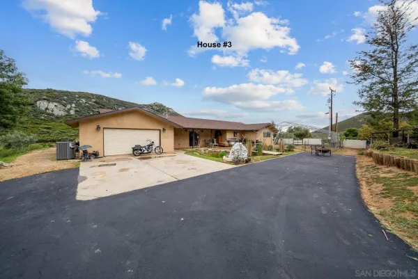 a view of house with outdoor space and parking