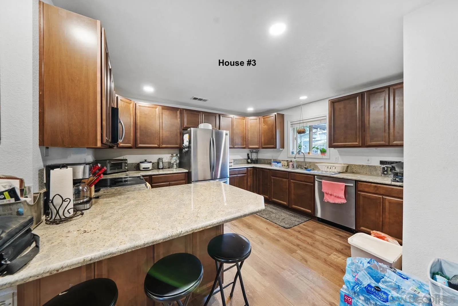 21908 Japatul Lane Alpine, CA 91901 - Photo 37 of 47 a kitchen with stainless steel appliances a sink a stove a refrigerator cabinets and wooden floor