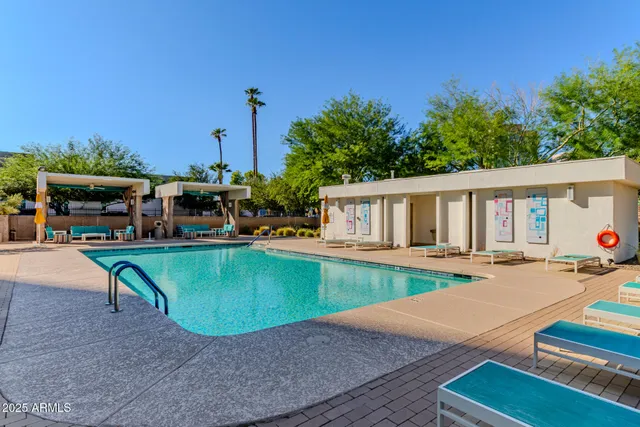a view of a house with pool and chairs