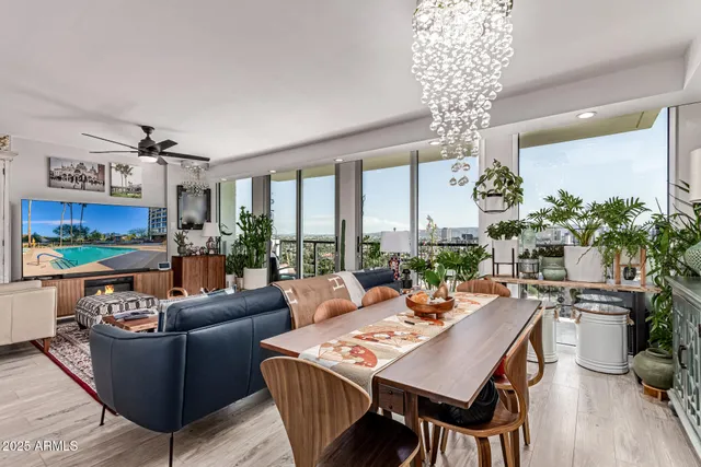 a living room with furniture a chandelier and a dining table