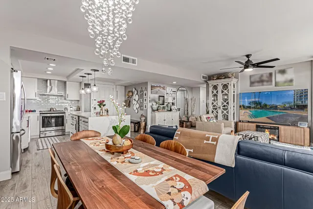a living room with furniture kitchen view and a chandelier