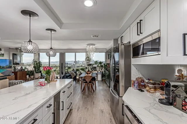 a kitchen filled with stainless steel appliances kitchen island granite countertop a lot of counter space and wooden floor