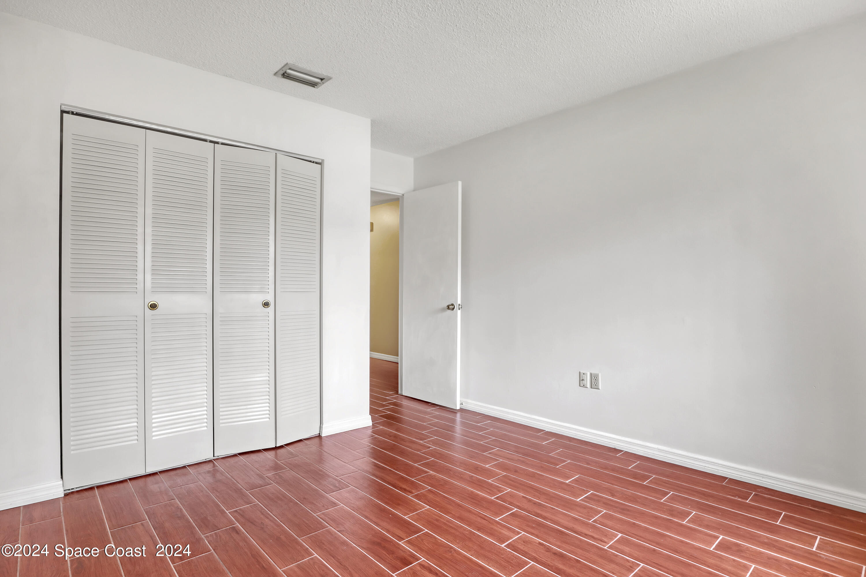 4733 Sisson Road Titusville, FL 32780 - Photo 12 of 26 a view of an empty room with wooden floor and closet
