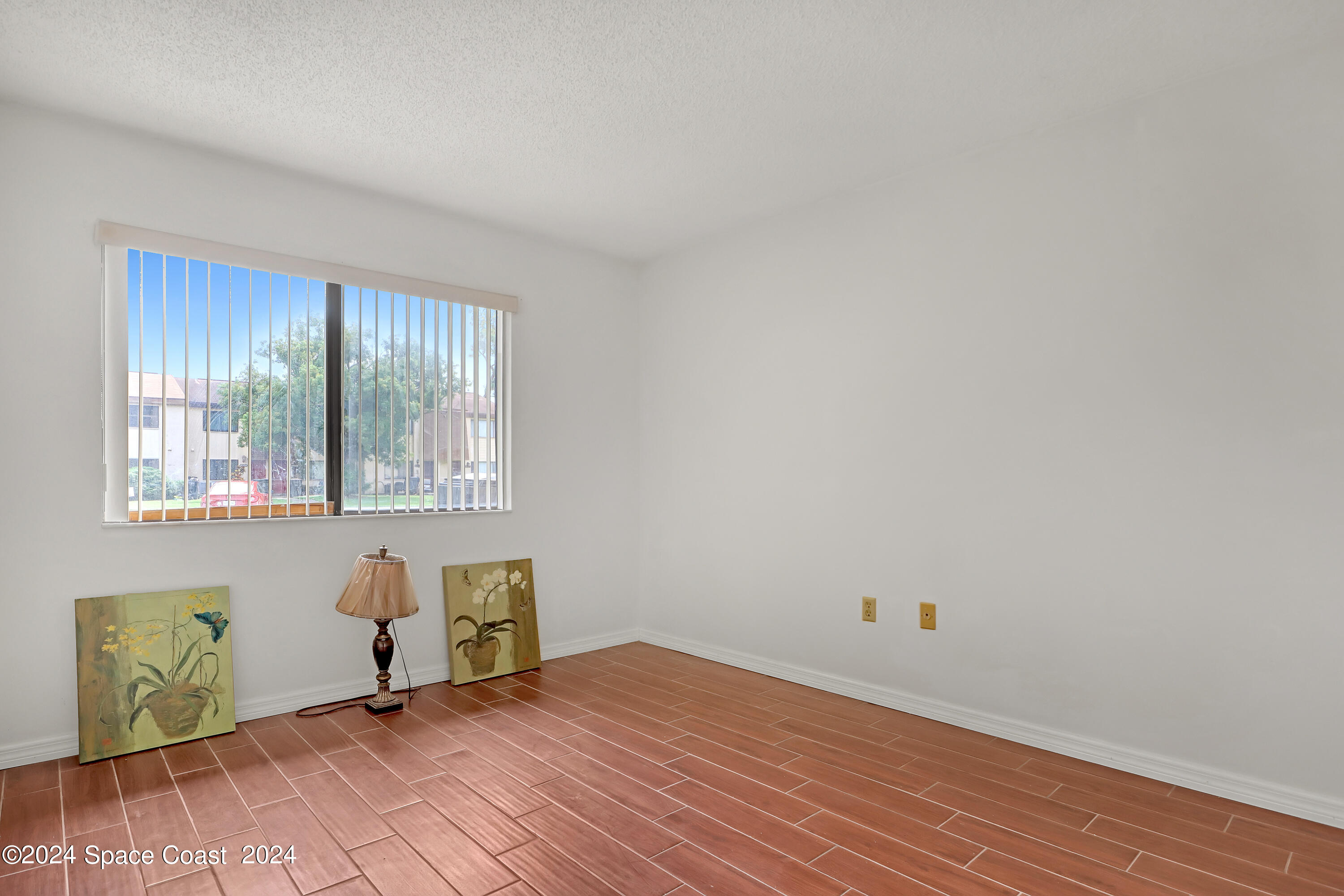 4733 Sisson Road Titusville, FL 32780 - Photo 13 of 26 a view of an empty room with wooden floor and a window
