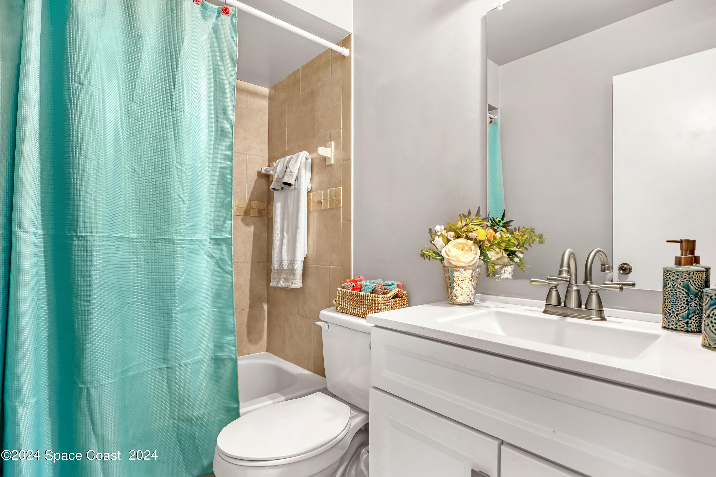 4733 Sisson Road Titusville, FL 32780 - Photo 14 of 26 a bathroom with a sink a toilet and shower curtain