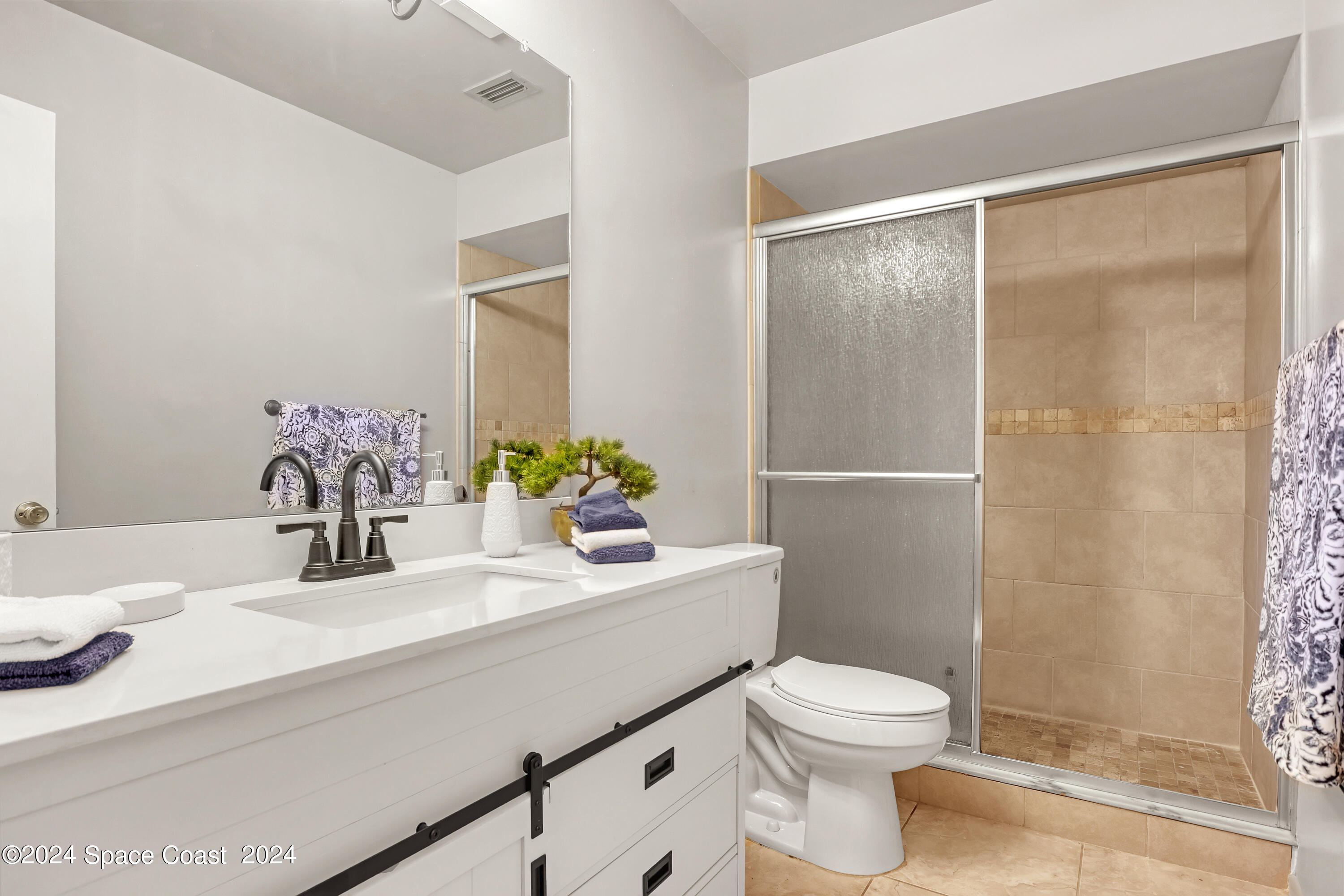 4733 Sisson Road Titusville, FL 32780 - Photo 20 of 26 a bathroom with a sink a toilet and shower