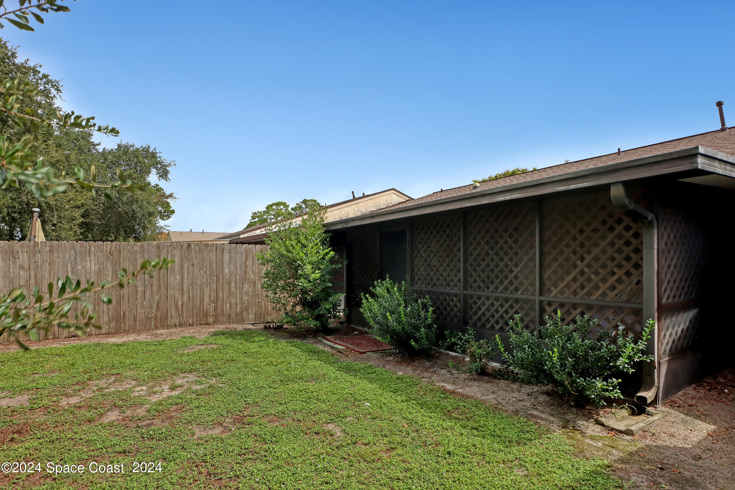 4733 Sisson Road Titusville, FL 32780 - Photo 24 of 26 a view of backyard with potted plants and wooden fence