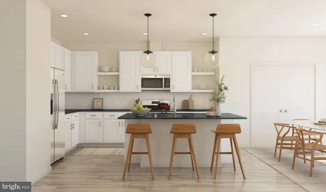 a kitchen with stainless steel appliances granite countertop a table chairs stove and white cabinets