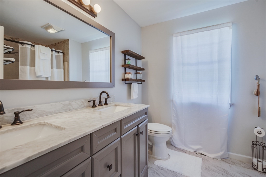 283 Christopher Drive Springfield, MA 01119 - Photo 23 of 32 a bathroom with a granite countertop sink a toilet and a mirror