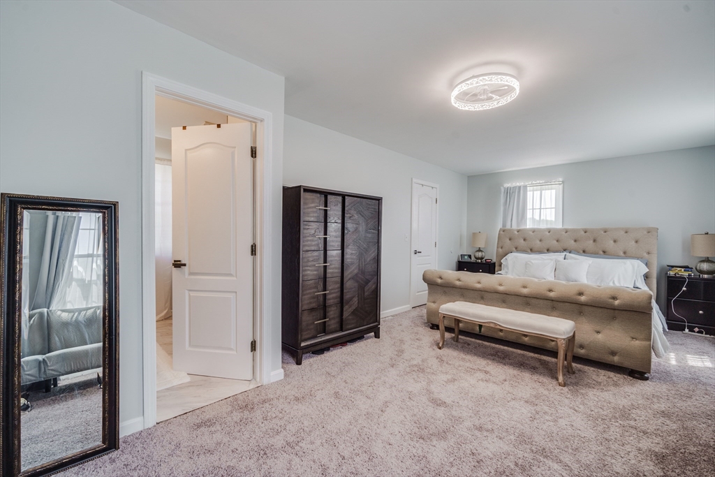 283 Christopher Drive Springfield, MA 01119 - Photo 24 of 32 a spacious bedroom with a bed and a glass door