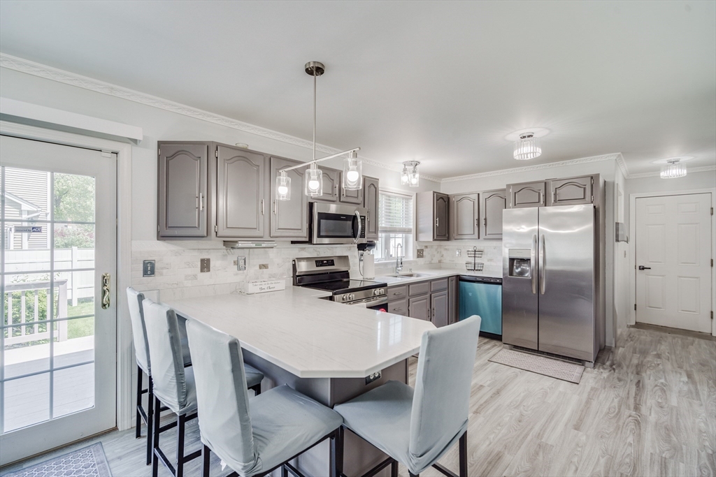 283 Christopher Drive Springfield, MA 01119 - Photo 5 of 32 a kitchen with refrigerator a sink and chairs