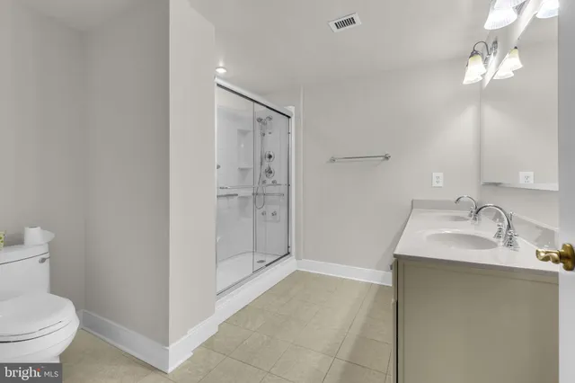 a bathroom with a granite countertop sink a toilet and shower