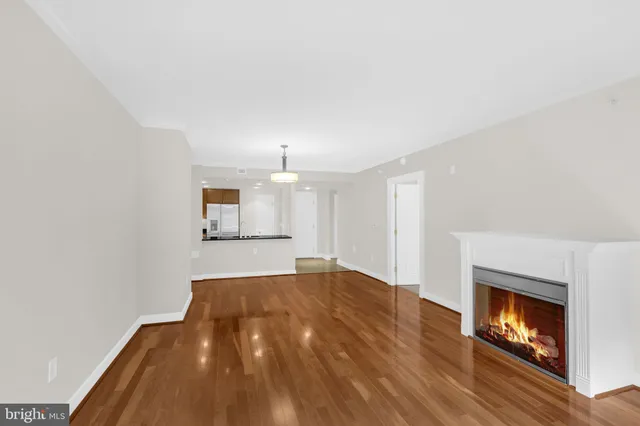 a view of empty room with wooden floor and fireplace