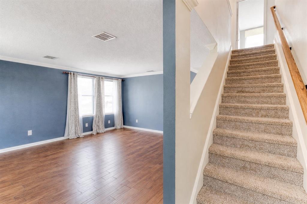 3601 McClintick Road McKinney, TX 75070 - Photo 5 of 24 a view of an empty room with wooden floor and stairs