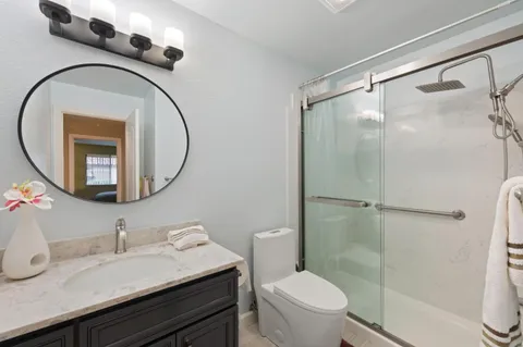 a bathroom with a sink a toilet and a mirror